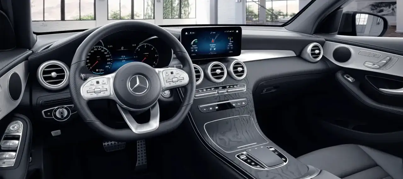 Wnętrze Mercedesa GLC Coupe. Cyfrowe zegary, ekran multimediów i kierownica z przyciskami. Sprawdź atrakcyjną mercedes glc coupe cena.