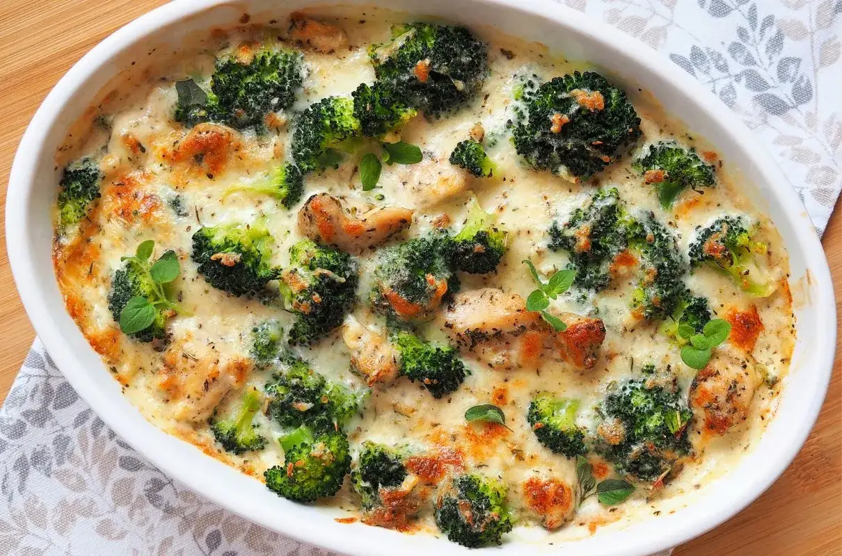 Pyszna zapiekanka z kurczakiem i brokułami w kremowym sosie, posypana ziołami.