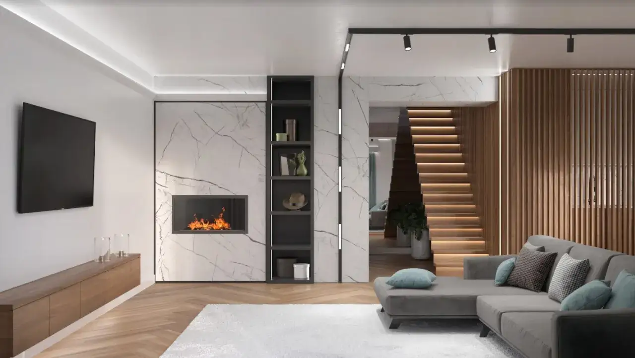 Nowoczesny salon z kominkiem i telewizorem, nad którym wiszą halogeny. Drewniane schody prowadzą na piętro.