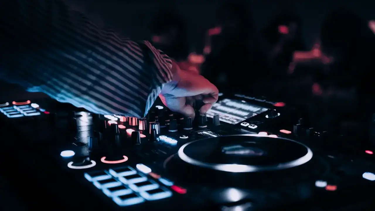 DJ przy konsoli, tworzy muzykę na wesele. Zastanawiasz się, ile kosztuje dj na wesele?