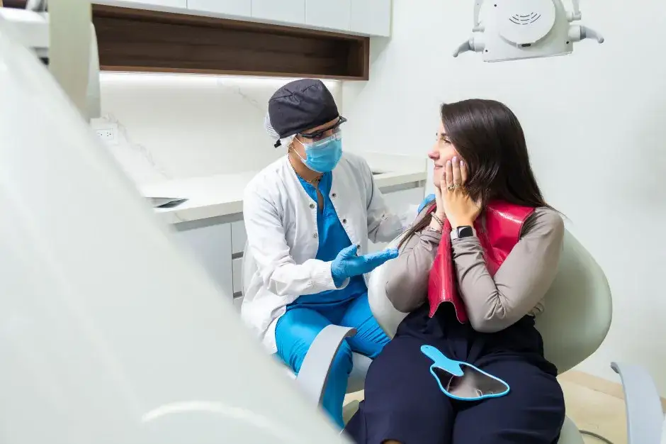 pacjent opisuje b&oacute;l zęba dentysta