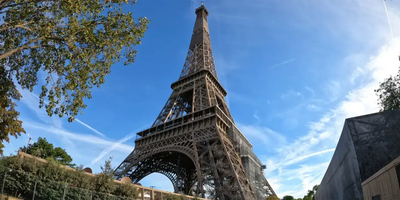 Wieża Eiffla pod błękitnym niebem. Zastanawiasz się, ile schodów ma Wieża Eiffla? To imponująca konstrukcja!