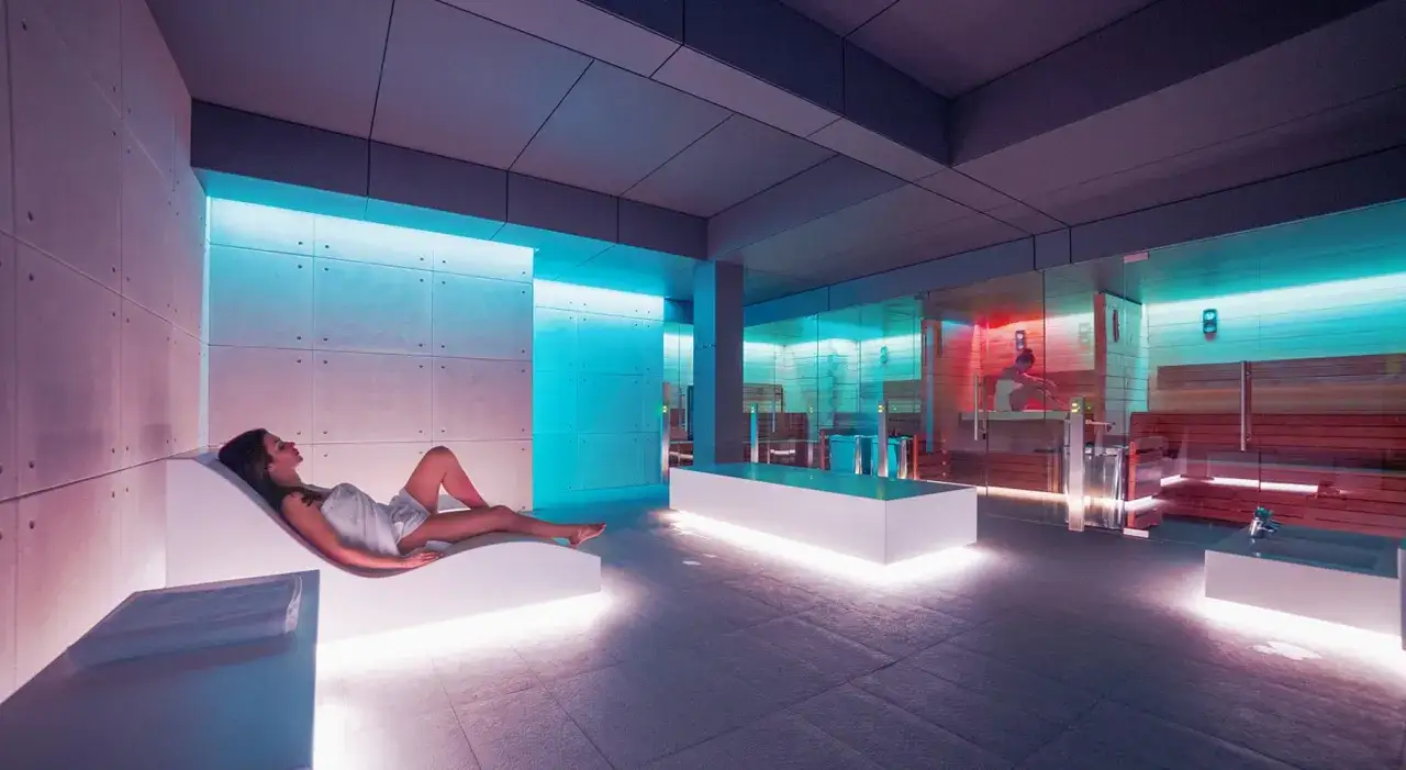 Osoba pakująca torbę na wyjazd do spa, z ręcznikiem i kosmetykami