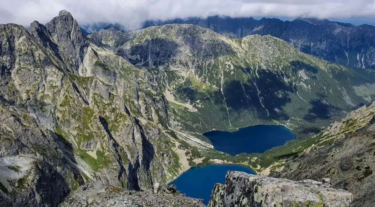 Widok z **świnica szczyt** na dwa g&oacute;rskie jeziora i skaliste zbocza Tatr.