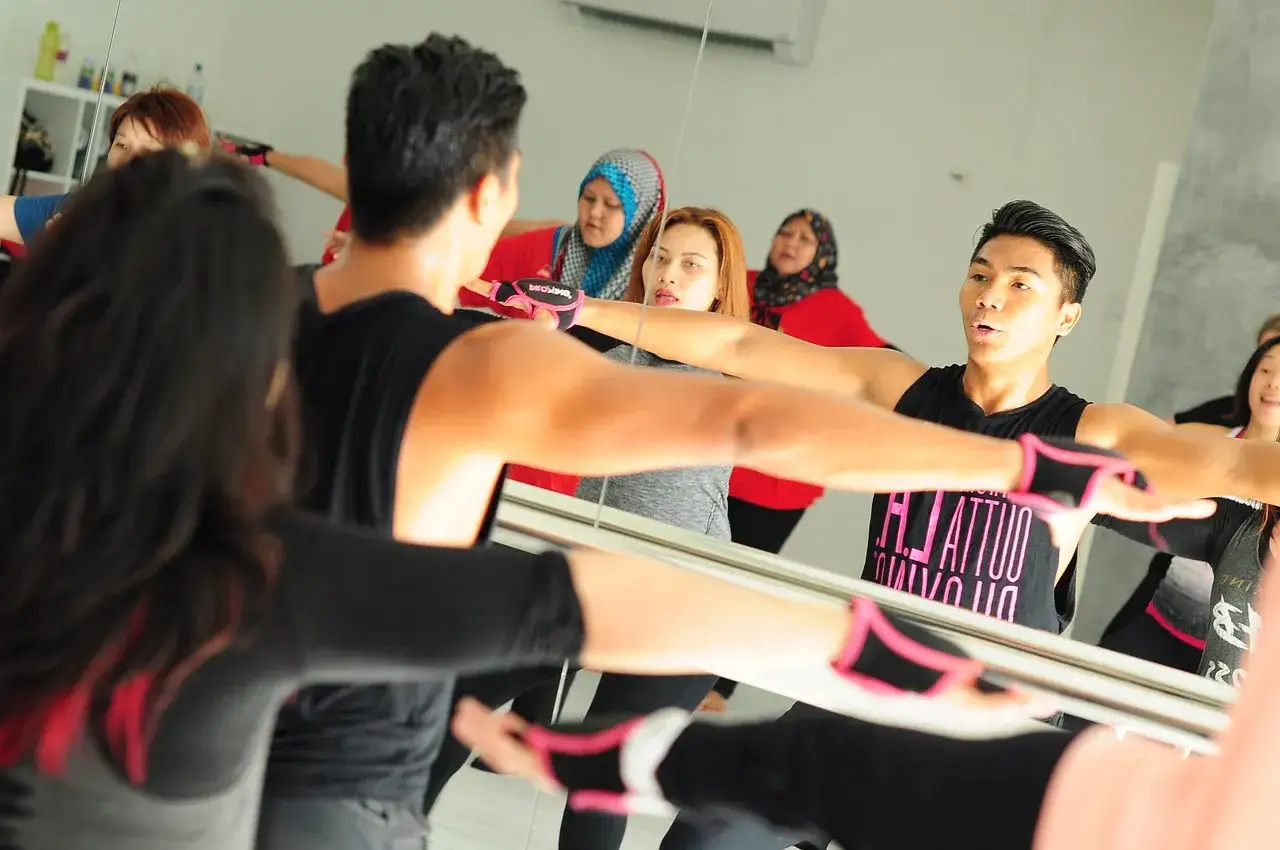 Grupa ćwiczy z instruktorem. Zastanawiasz się, ile zarabia instruktor fitness?