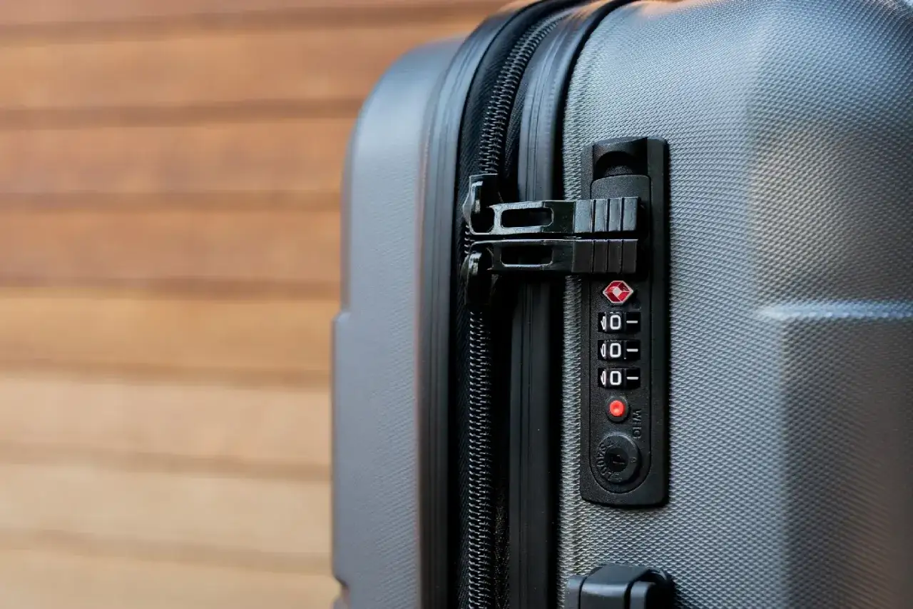 Zamek szyfrowy walizki z czerwonym kółkiem przy cyfrze. Dowiedz się, jak otworzyć zablokowany zamek w walizce, gdy zapomnisz kodu.