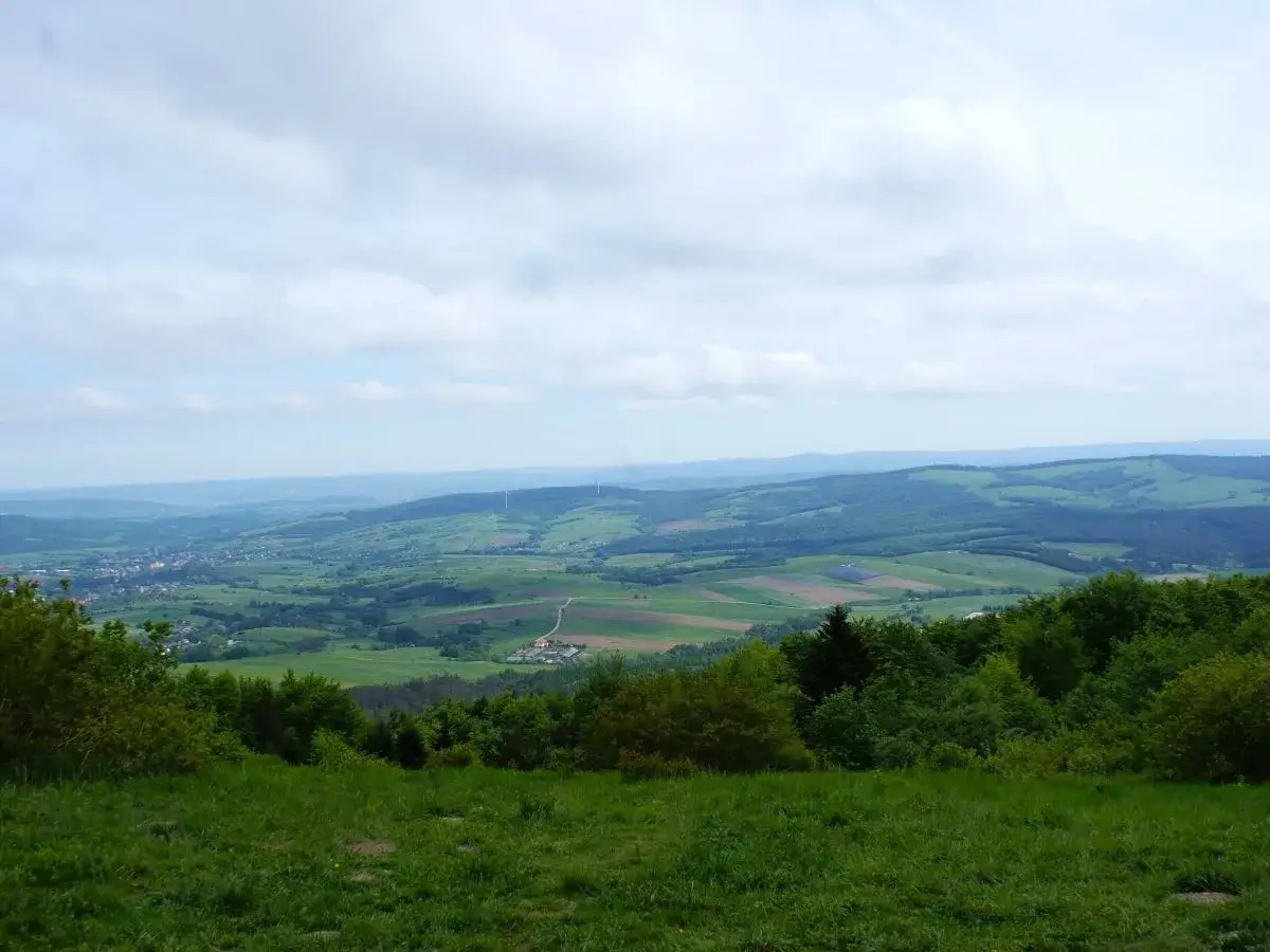 Widok z tokarnia szczyt na zielone wzgórza, pola i miasteczko w oddali.
