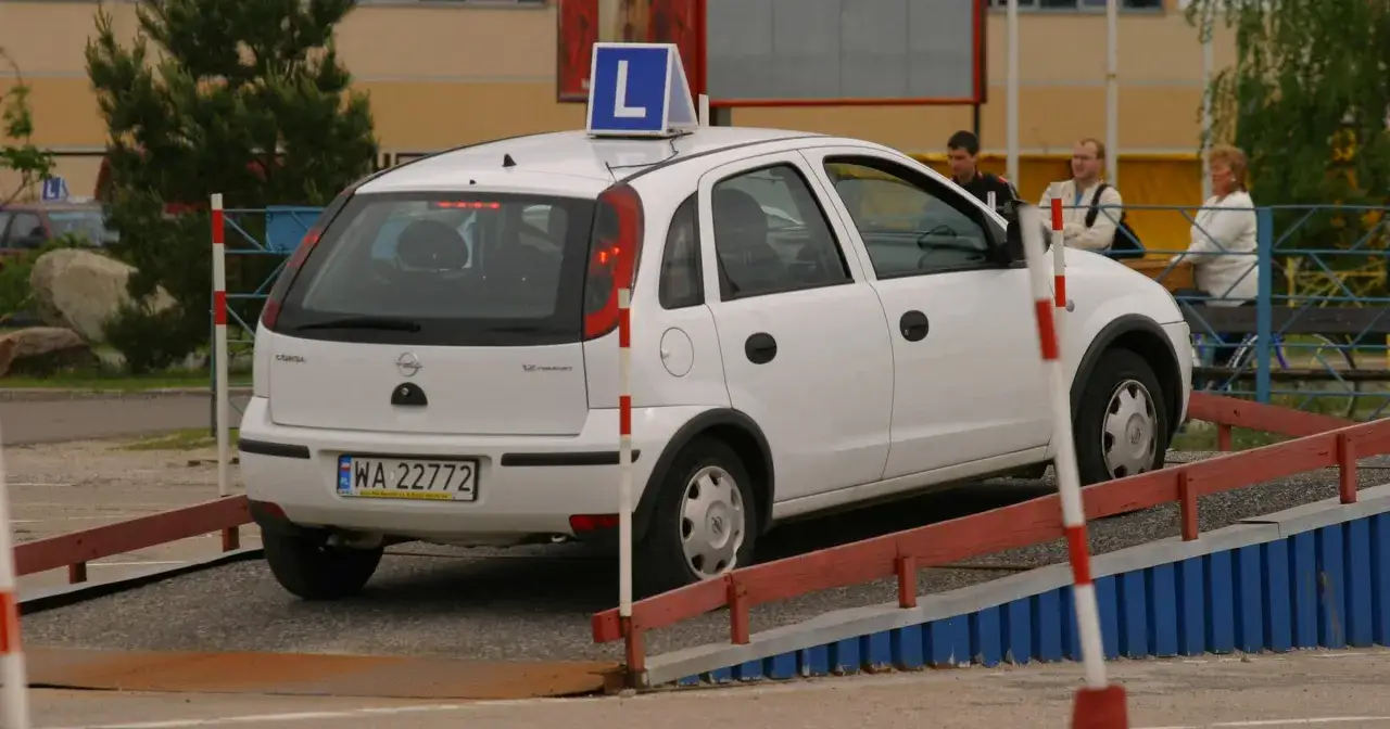 Biały Opel z literą 