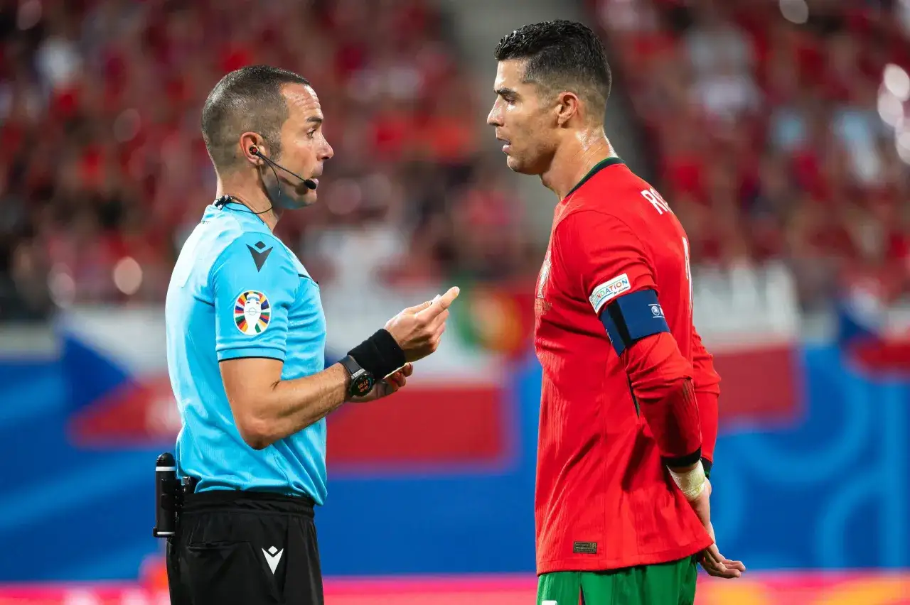Sędzia wyjaśnia Cristiano Ronaldo zasady piłki nożnej.