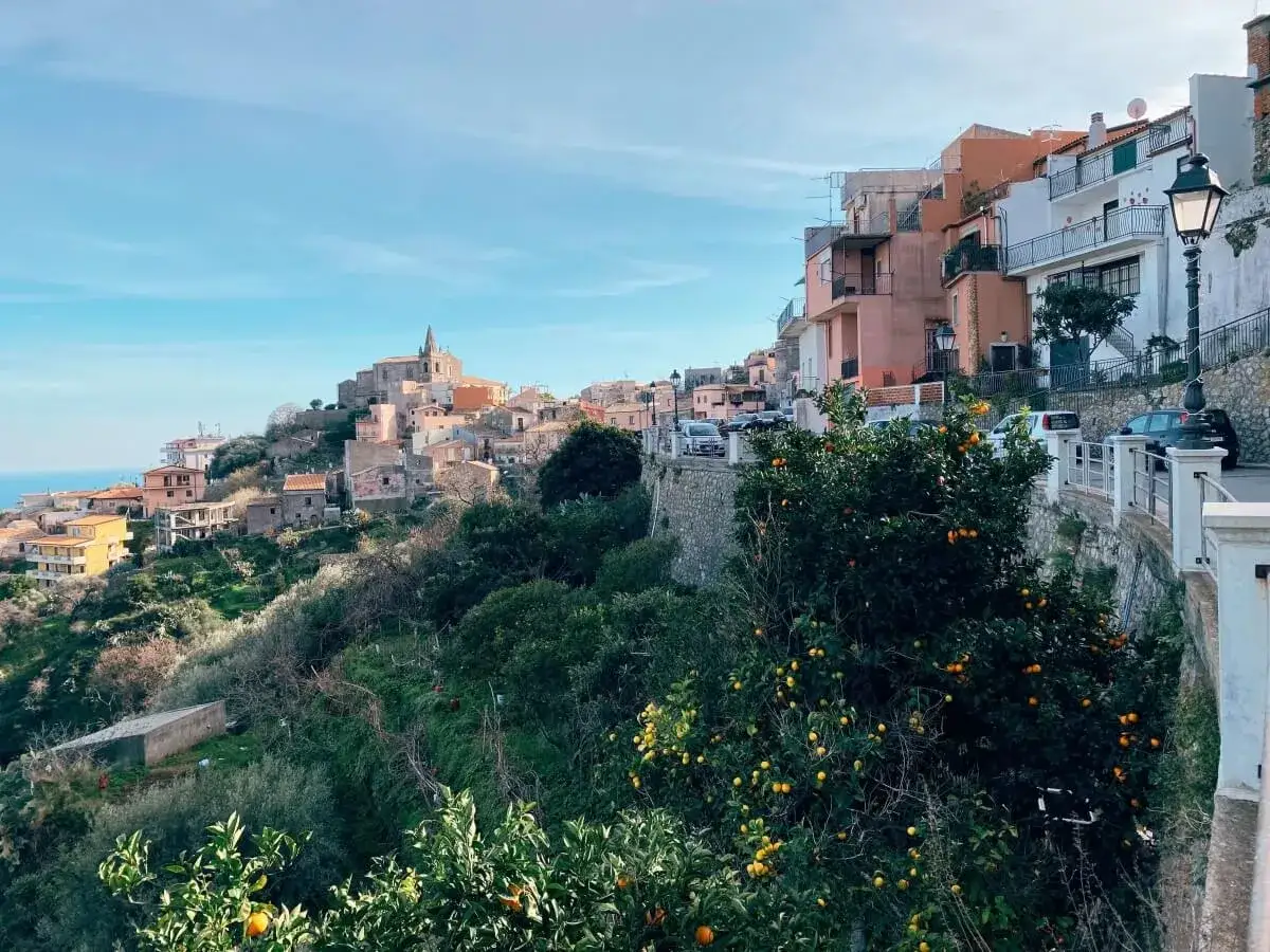 Widok na sycylijską wioskę z pomarańczami na drzewach. Idealny czas na wizytę, kiedy najlepiej lecieć na Sycylię, to wiosna.