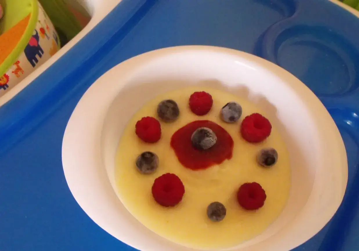 Pyszna kasza manna na wodzie, ozdobiona malinami i bor&oacute;wkami, wygląda jak słoneczko na talerzu.