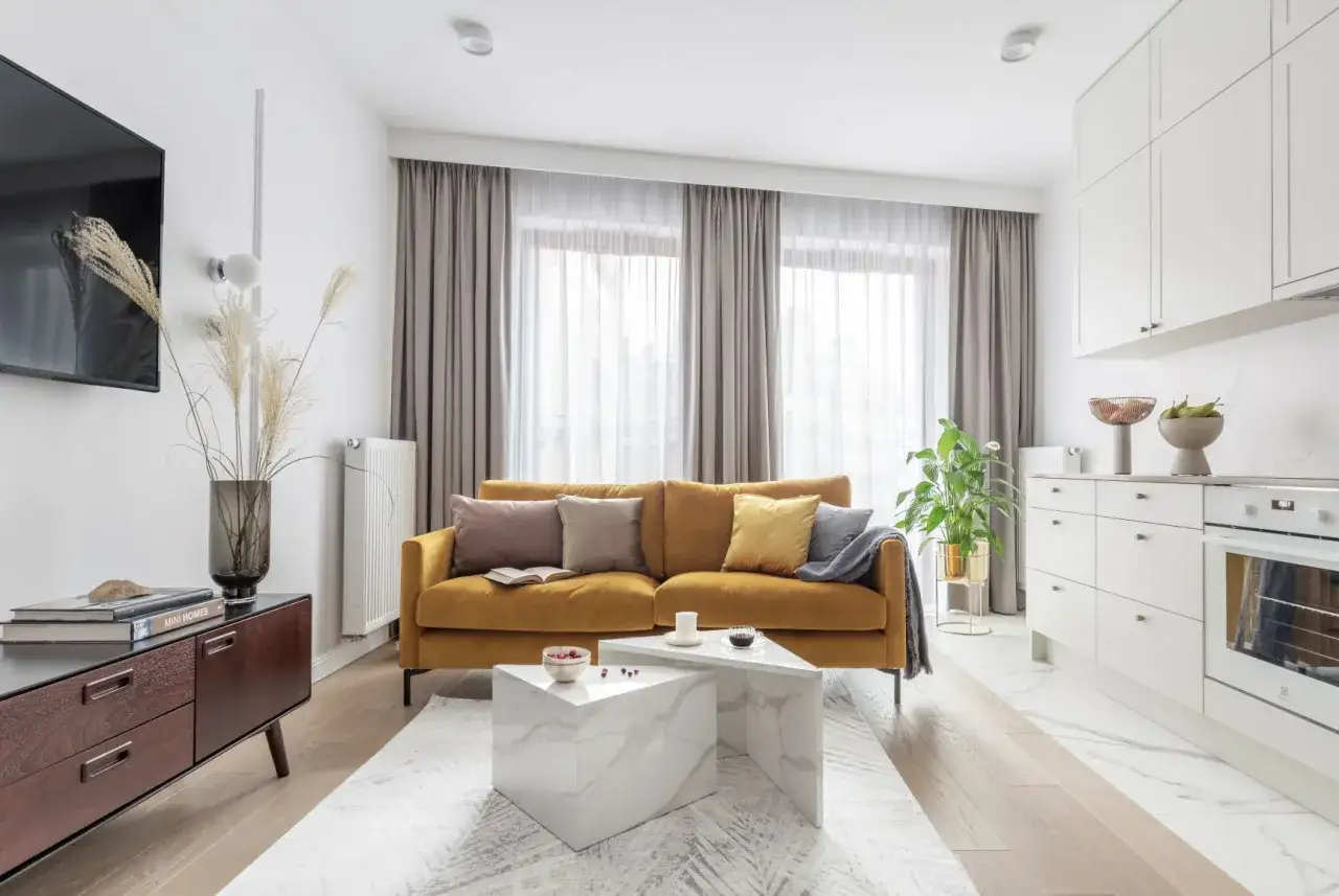 Nowoczesna dekoracja okien z zasłonami w neutralnych kolorach, tworząca przytulną atmosferę w salonie.