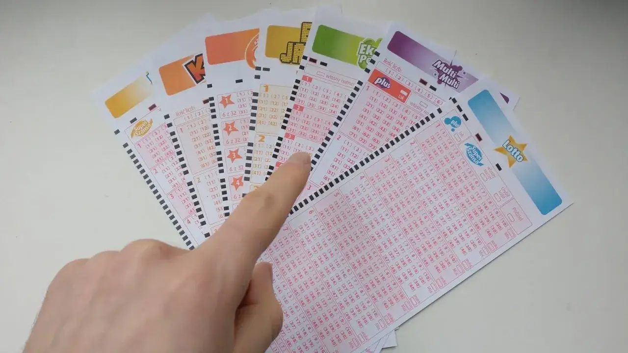 Dłoń zaznacza liczby na kuponach lotto. Czy to będą gorące liczby ekstra pensja?