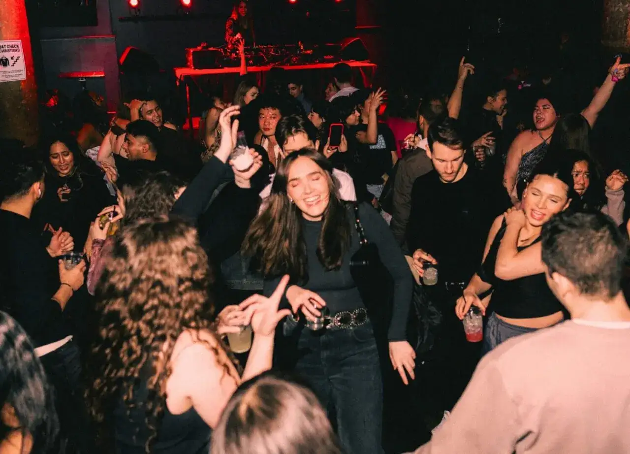 Tłum bawi się przy gorących latynoskich piosenkach do tańca w klubie. Ludzie tańczą, piją i cieszą się nocą.