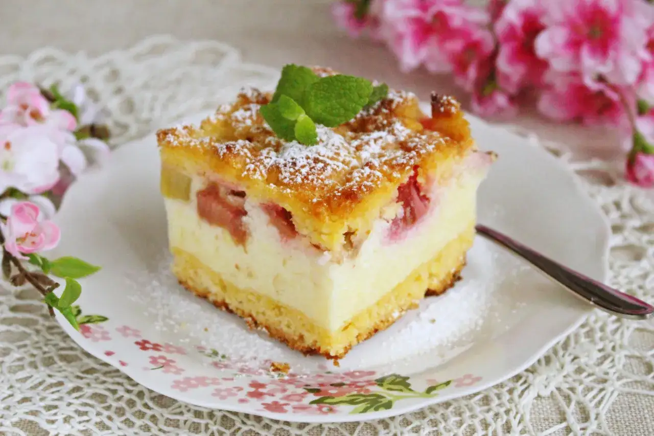 Ruda w kuchni: pyszne ciasto z rabarbarem i kremem, posypane cukrem pudrem i miętą. Idealne na wiosenne popołudnie.