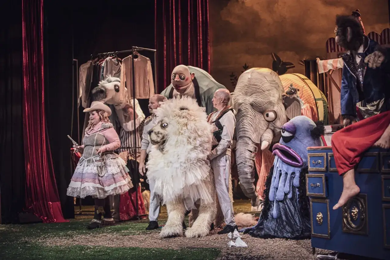 Co to jest teatr? Definicja dla dzieci: scena pełna postaci - kowbojka, wielki lew, słoń i inne stwory bawią się na przedstawieniu.