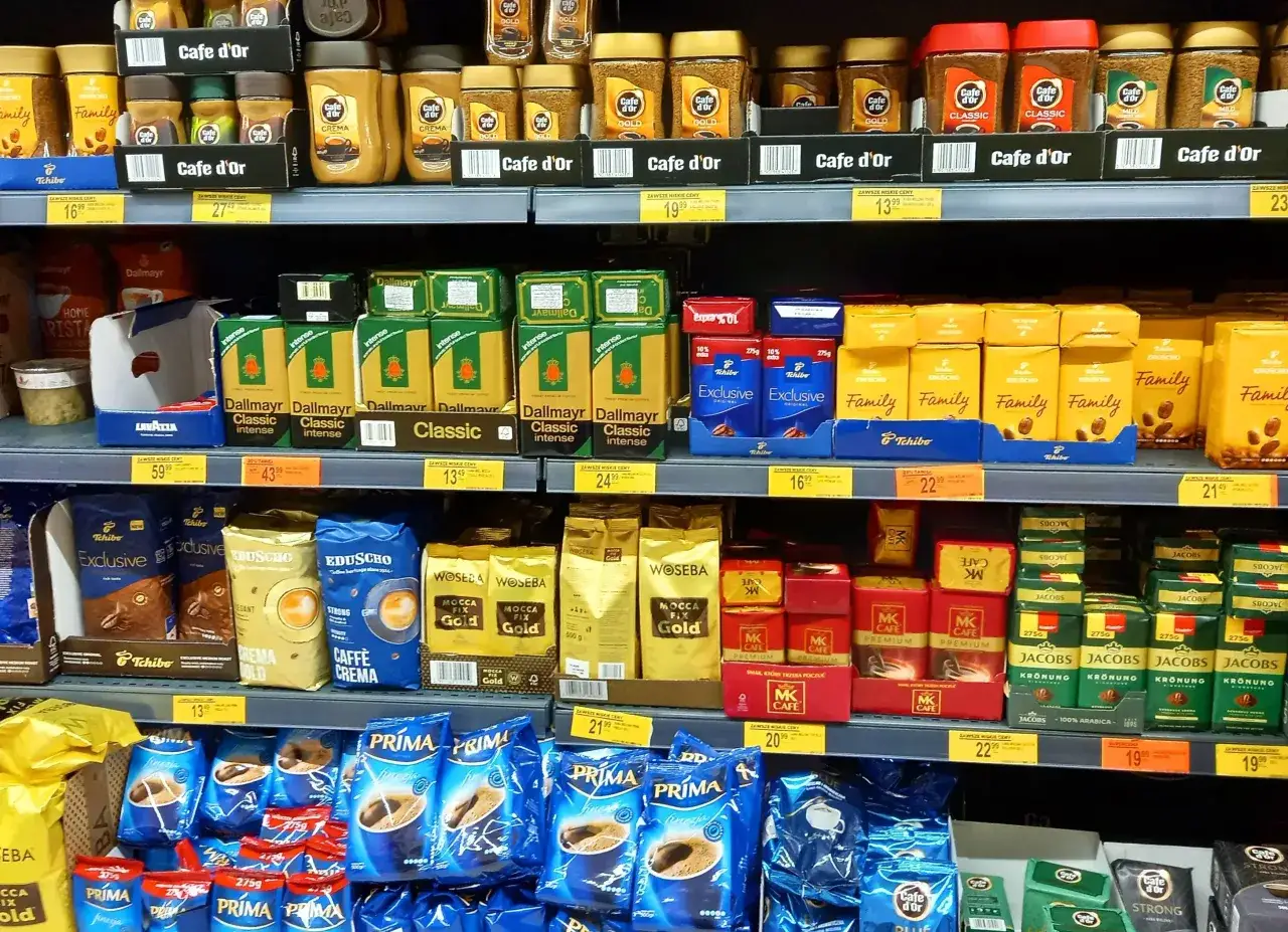 Półki sklepowe uginają się od kawy. Właściciel małego sklepu spożywczego zastanawia się, ile zarabia po odliczeniu podatków.