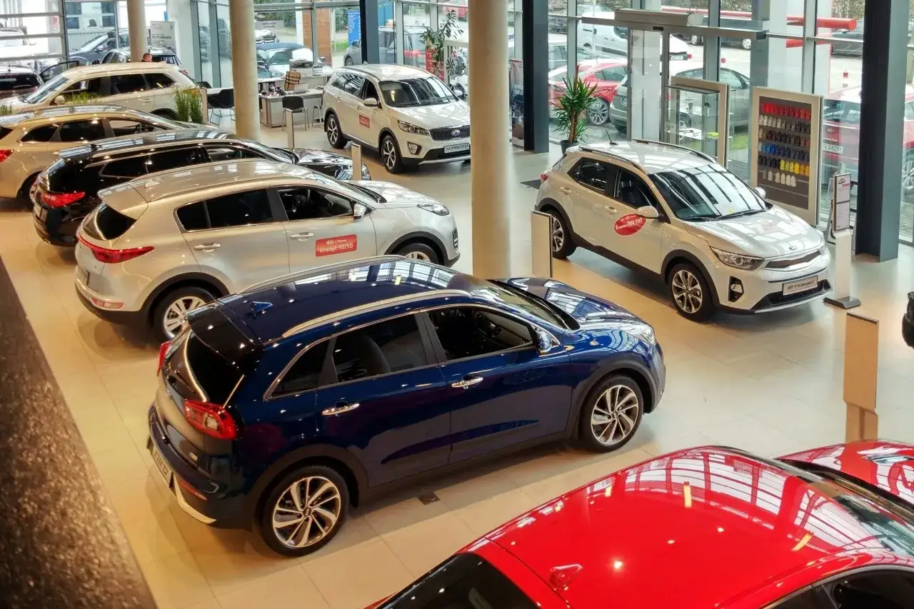 Salon samochodowy pełen nowych aut. Zastanawiasz się, jak negocjować cenę samochodu w salonie? Te modele mogą być Twoje!