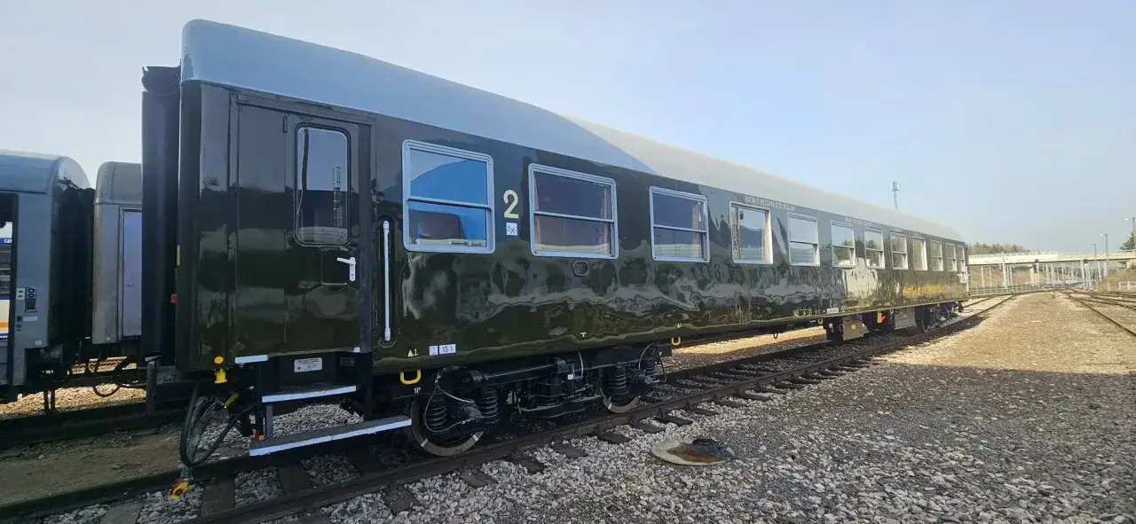 Ciemnozielony wagon kolejowy na torach. Zastanawiasz się, ile jest kilometrów z Poznania do Krakowa?