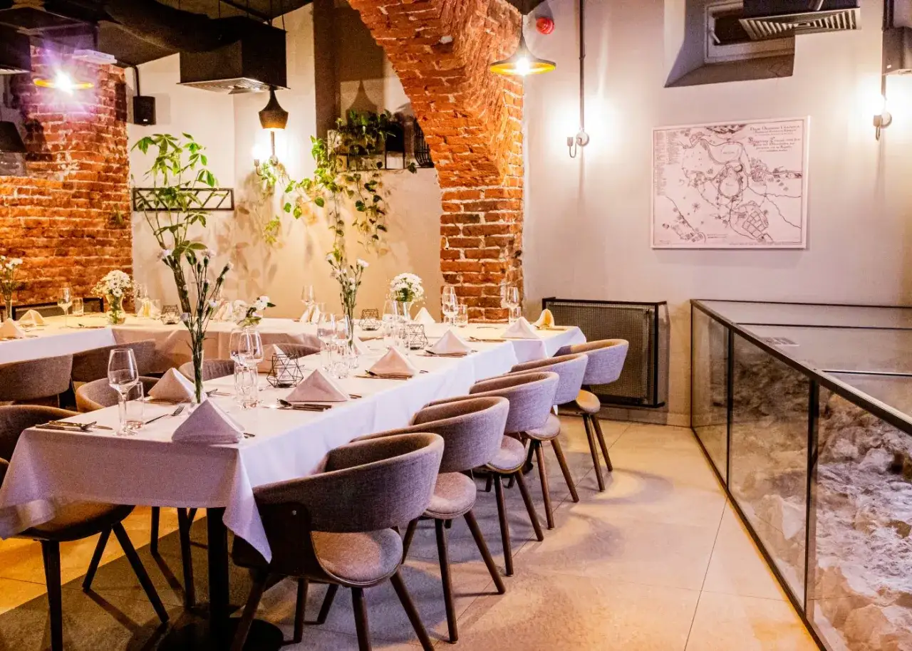 Elegancko nakryte stoły w restauracji, gotowe na przyjęcie. Zastanawiasz się, ile kosztuje przyjęcie urodzinowe w restauracji?