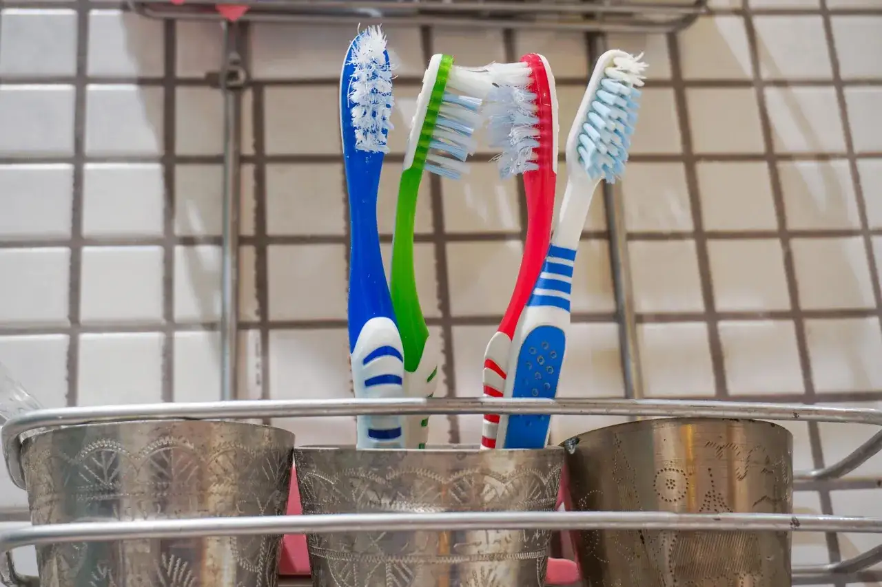 Zużyte szczoteczki do zębów w metalowym kubku. Czas pomyśleć, gdzie wyrzucić szczoteczkę do zębów, gdy jej włosie jest już zniszczone.