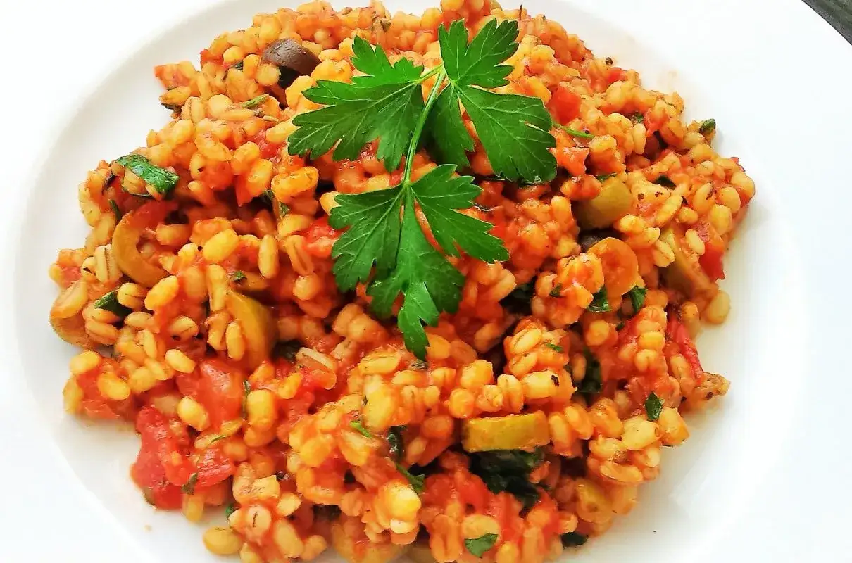 Pęczak w sosie pomidorowym z oliwkami i natką pietruszki. Świetny pomysł, co zrobić z ugotowanej kaszy pęczak na szybki obiad.