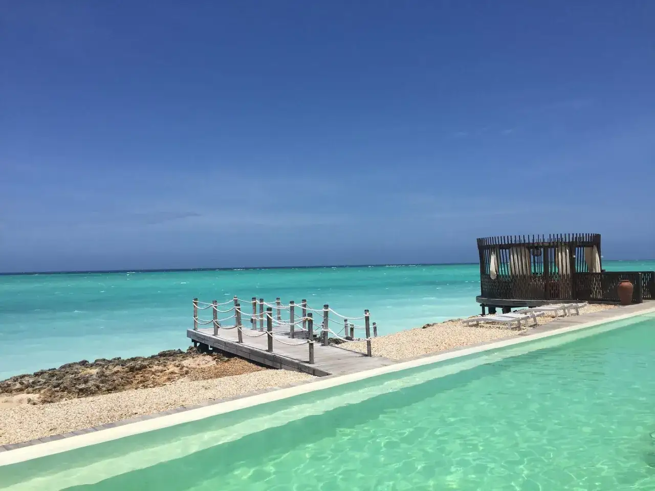 Turkusowe morze, basen i drewniana altana na Zanzibarze. Sprawdź atrakcyjne zanzibar ceny i zaplanuj wymarzone wakacje.
