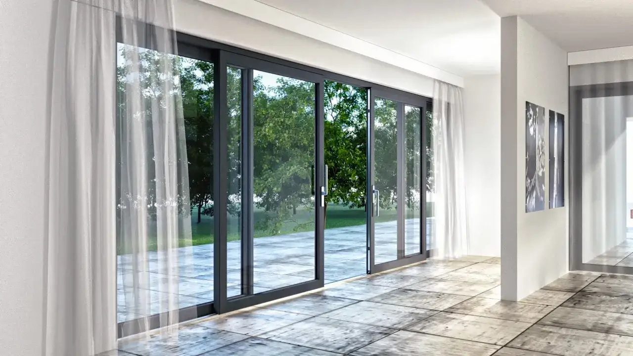 Nowoczesny wystr&oacute;j okna tarasowego z białymi zasłonami i widokiem na zielony ogr&oacute;d.