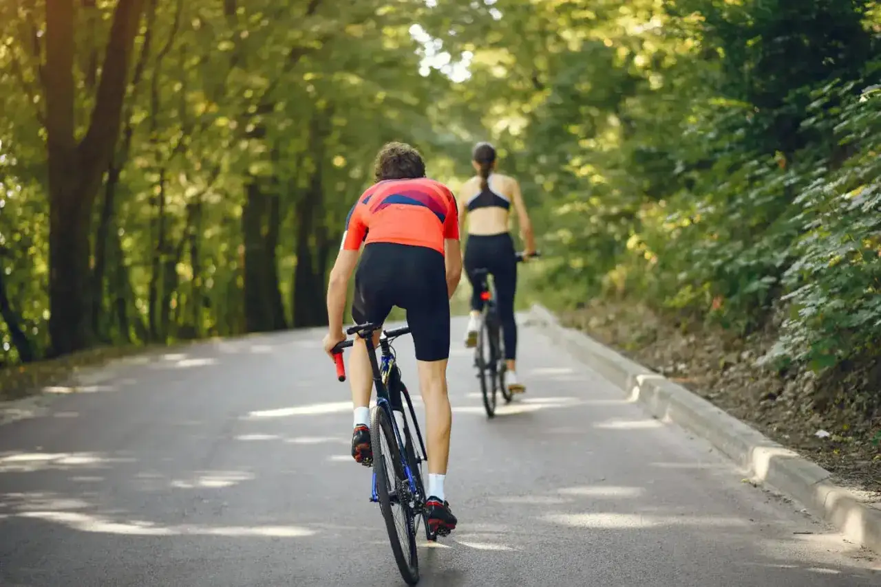 Dwie osoby jadące rowerami po lesie, utrzymując przyjemną, średnią prędkość.