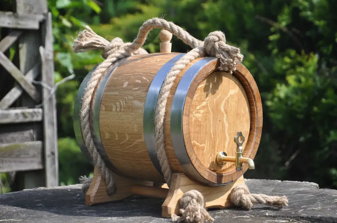 Drewniana beczka z kranikiem i liną, idealna do piwnicy. Czy warto leżakować piwa rzemieślnicze (barrel aged) w piwnicy?