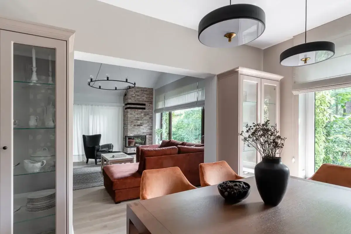Nowoczesny dom w stylu holenderskim z ceglanym kominkiem, wygodną kanapą i przeszklonymi witrynami.