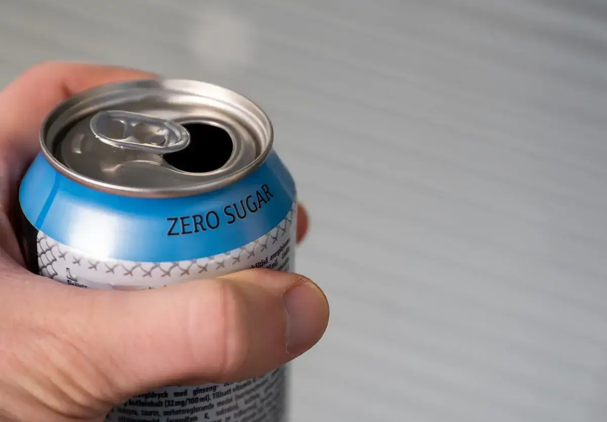 Dłoń trzyma puszkę napoju 