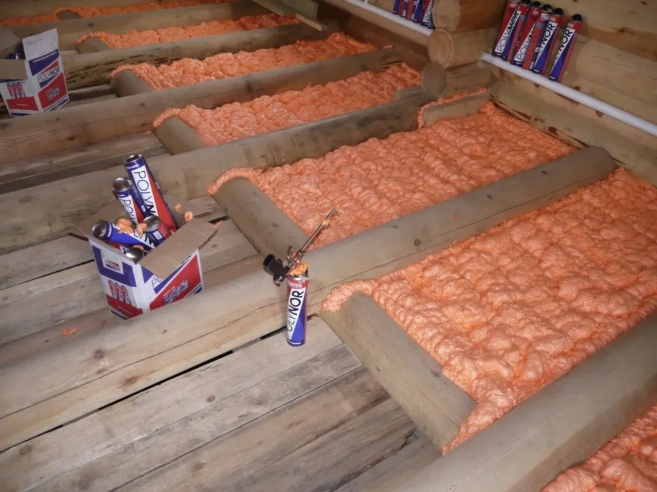 Zestaw do samodzielnego natrysku pianki izolacyjnej w trakcie prac. Puszki z pianką i aplikator gotowe do użycia.