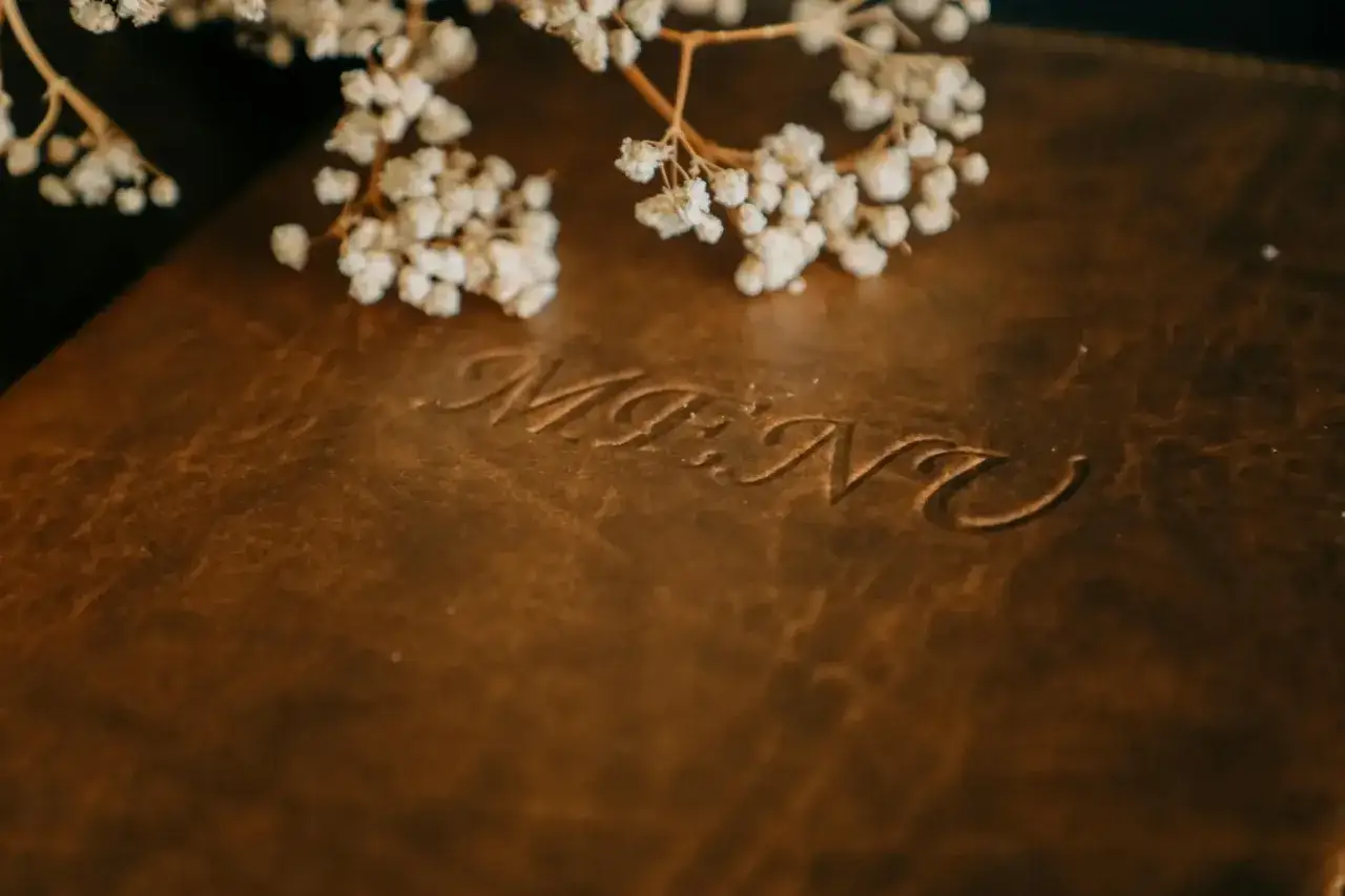 Brązowa okładka menu weselnego z wygrawerowanym napisem 