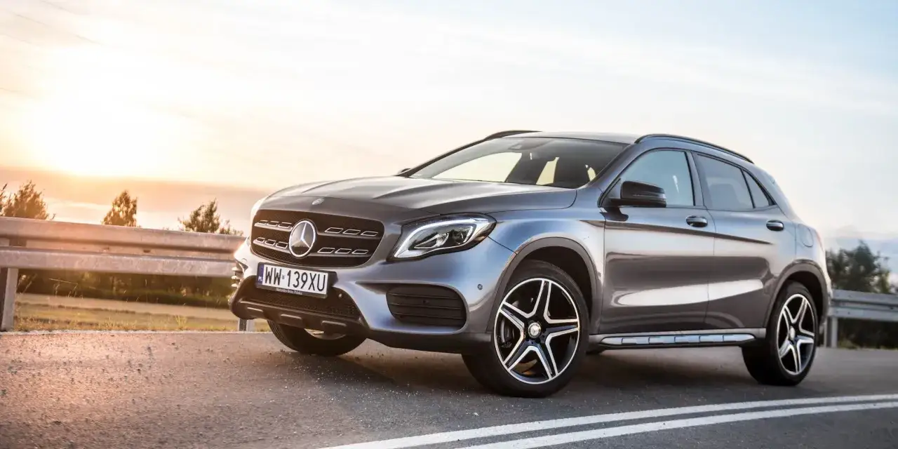 Szary Mercedes GLA 4Matic na drodze o zachodzie słońca.