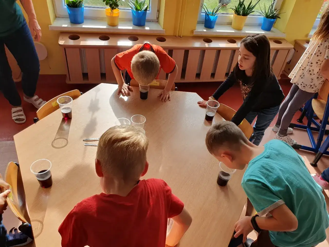 dzieci wykonujące eksperyment z czerwoną kapustą