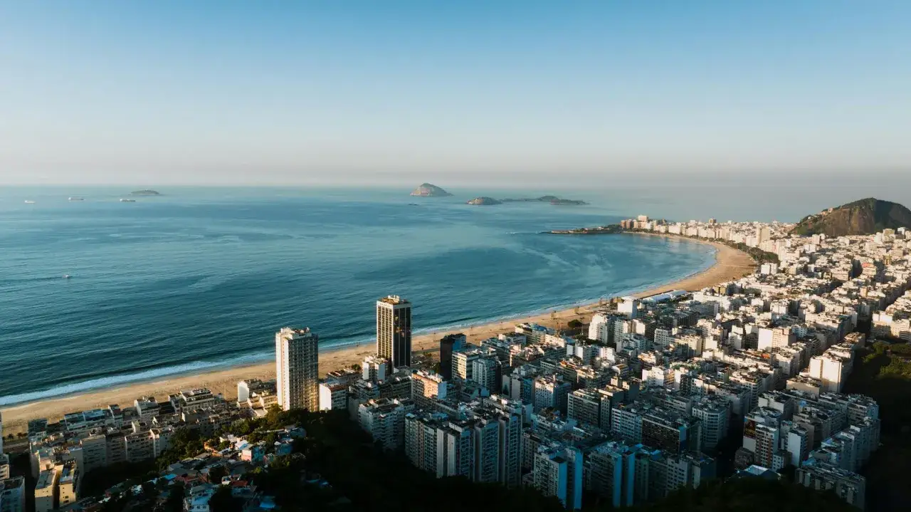 Widok na wybrzeże Rio de Janeiro z plażą i budynkami. Czy Brazylia jest bezpieczna? To pytanie nurtuje wielu, ale widok ten sugeruje spokój i piękno.