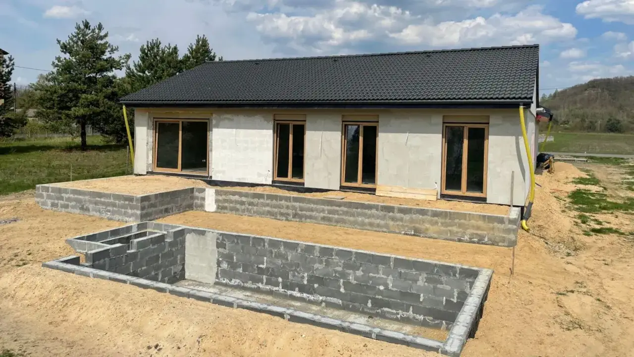 Budowa domu z perlitu w toku. Fundamenty i ściany zewnętrzne gotowe, czekają na dalsze prace.