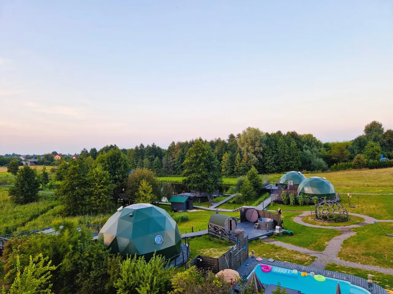 Malowniczy camping nad stawami z kopułowymi namiotami, basenem i sauną. Idealne miejsce na relaks wśród zieleni.