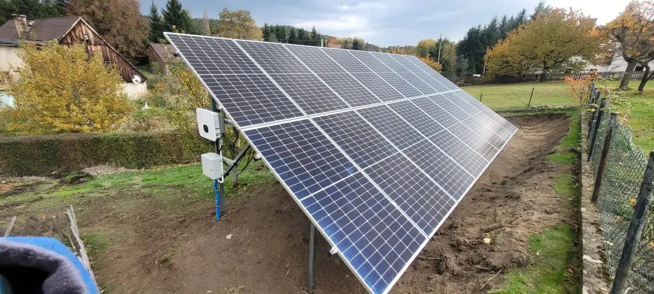 Solidna konstrukcja pod panele fotowoltaiczne na gruncie, gotowa do montażu. W tle jesienne drzewa i dom.