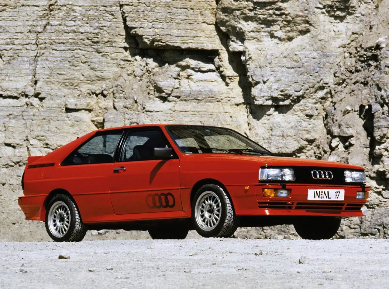 Czerwone audi quattro z lat 80. na tle skalnej ściany. Ikona rajdów i motoryzacji.