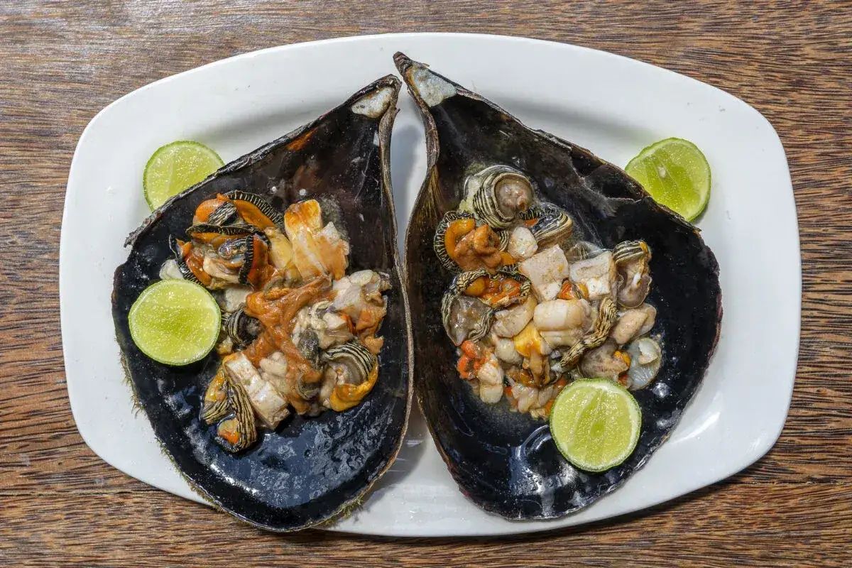 Dwa talerze z owocami morza w muszlach, podane z limonką. Zastanawiasz się, ile kosztuje obiad na Zanzibarze?