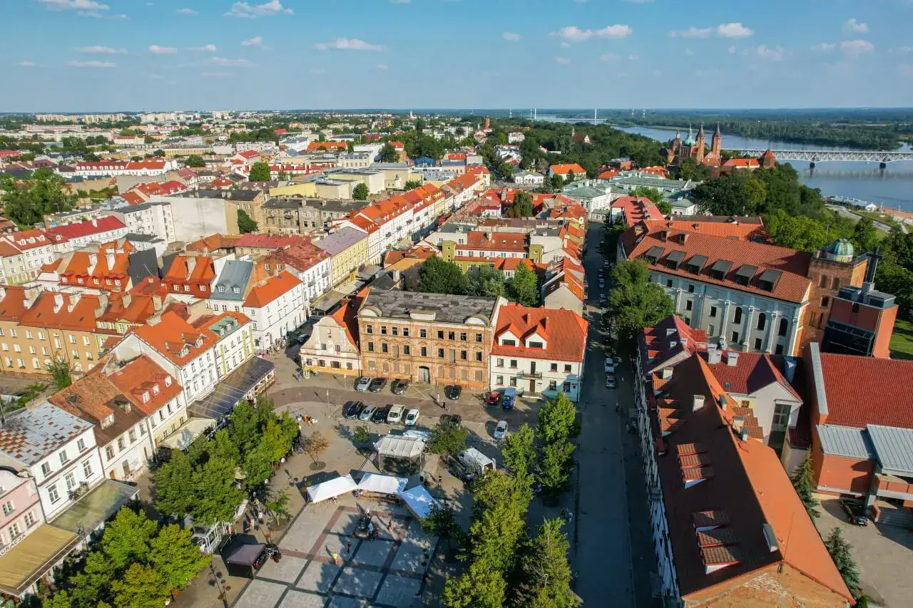 Widok z lotu ptaka na rynek i zabytkowe kamienice. W oddali Wisła i katedra. Idealne miejsce, by zobaczyć w Płocku.