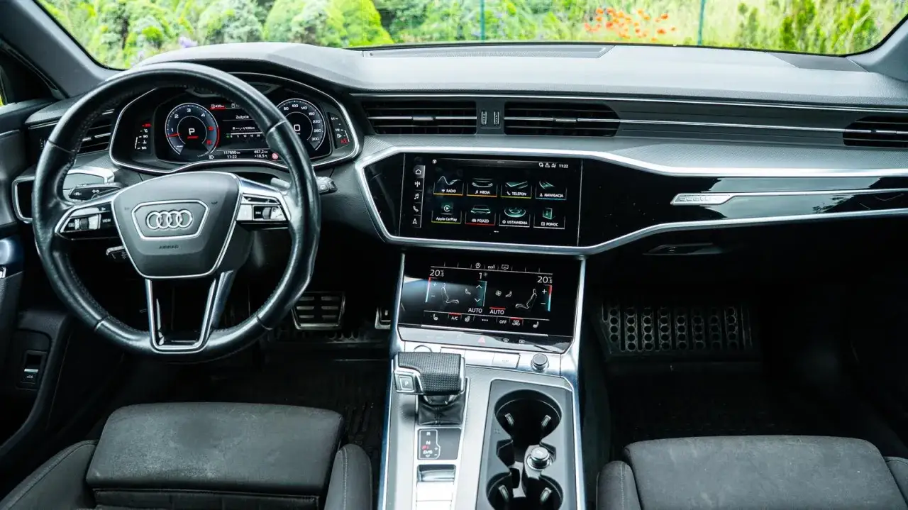 Wnętrze Audi A6. Na desce rozdzielczej widać ekran multimediów i cyfrowe zegary. Zastanawiasz się nad pojemnością baku?