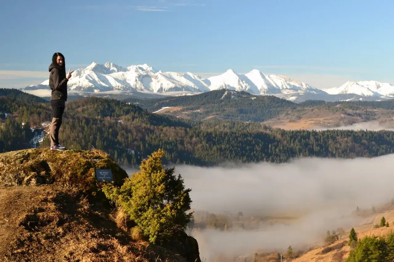 Kobieta na skale z widokiem na g&oacute;ry i morze mgły. To piękne lesnicke sedlo, idealne na spacer.
