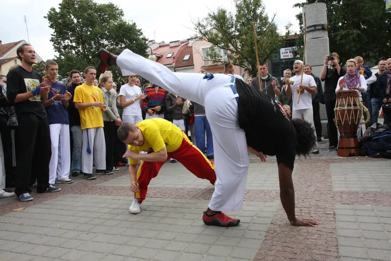 Capoeira co to? Dw&oacute;ch mężczyzn wykonuje akrobatyczne ruchy podczas pokazu.