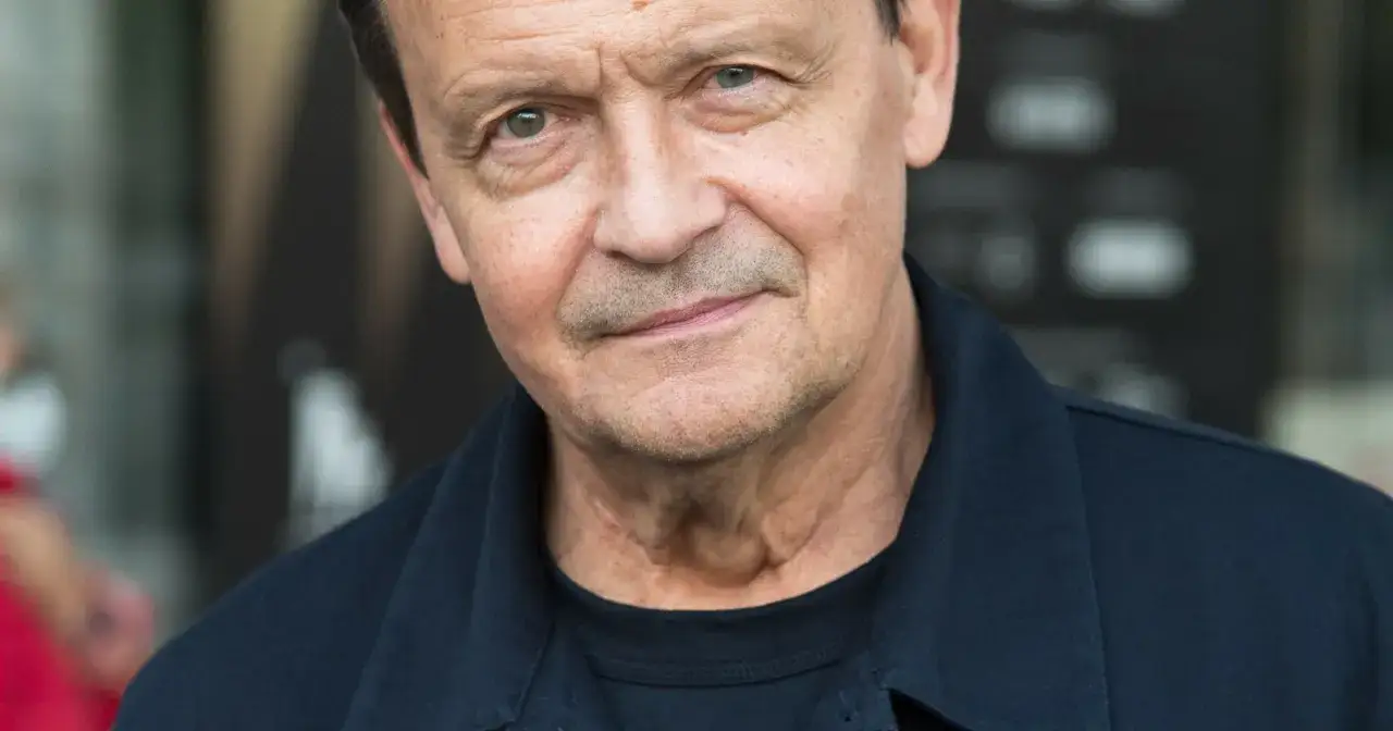 Zbliżenie na twarz Jana Frycza, aktora znanego z wielu filmów, seriali i programów.