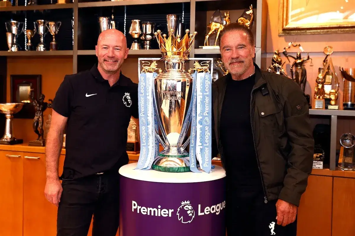Arnold Schwarzenegger i Alan Shearer, były król strzelców Premier League, pozują z pucharem ligi.