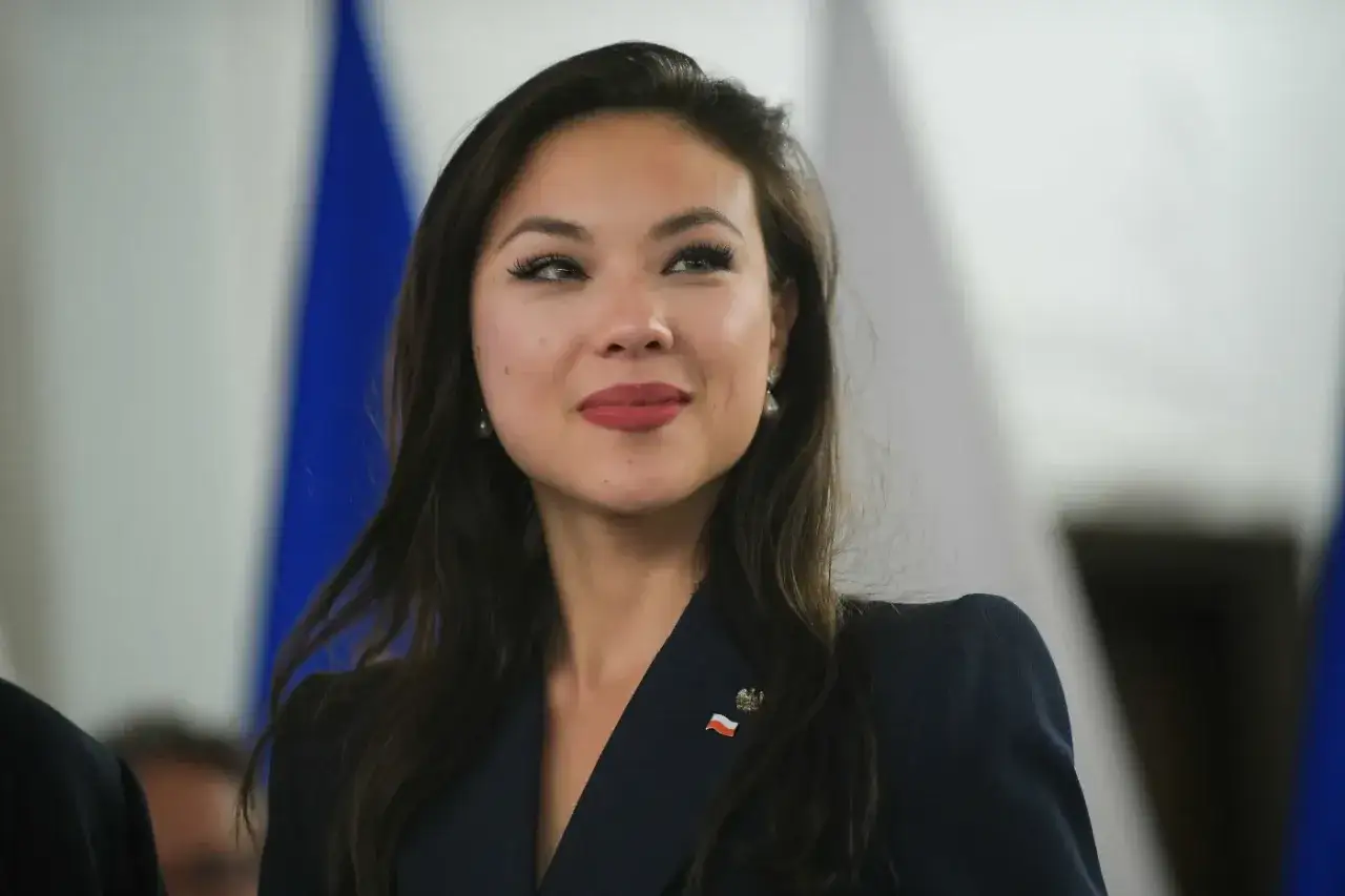 Uśmiechnięta posłanka Koalicji Obywatelskiej z przypinką z polską flagą.