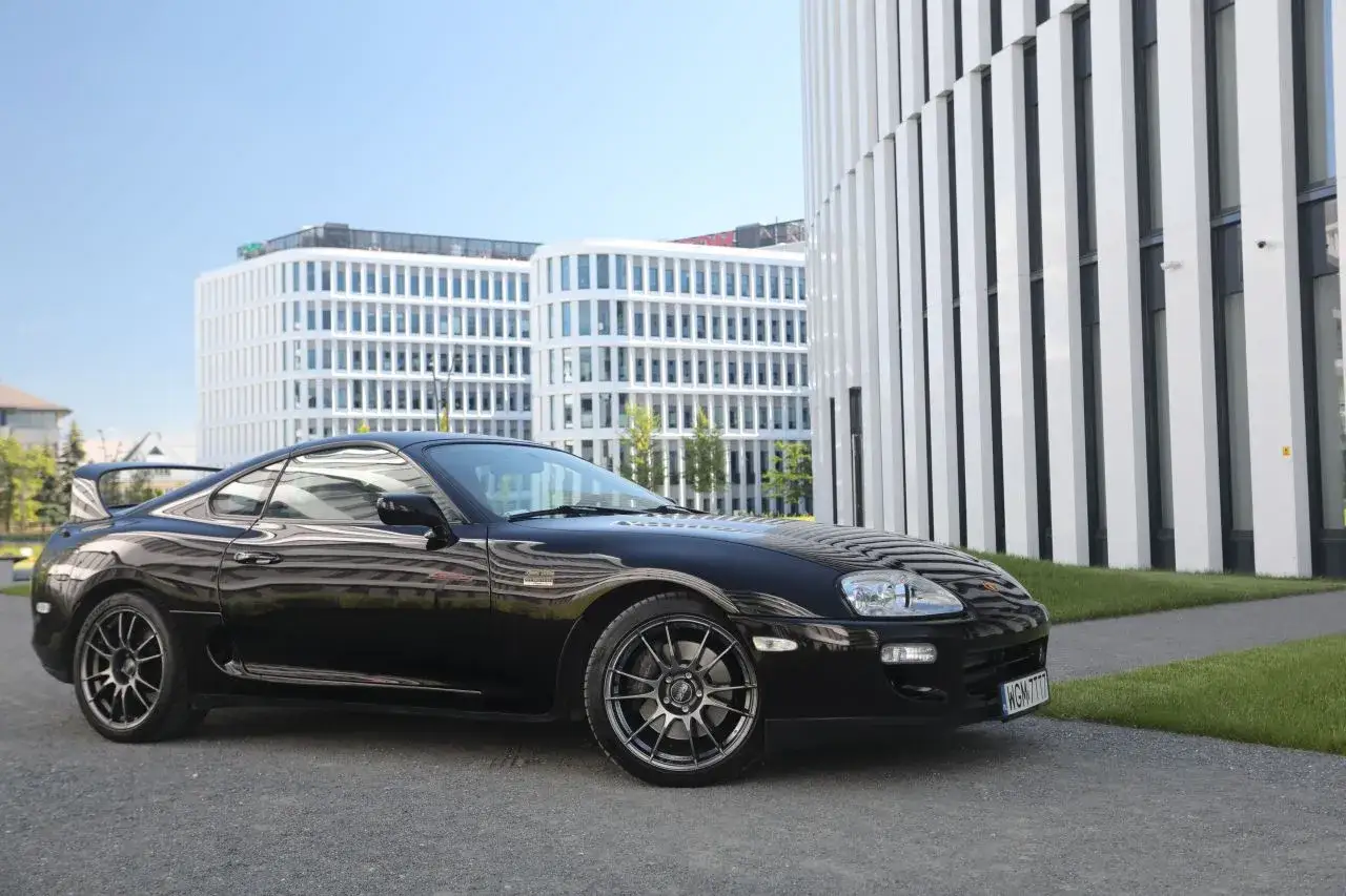 Czarna Toyota Supra na tle nowoczesnych budynków. Zastanawiasz się, ile kosztuje Toyota Supra?